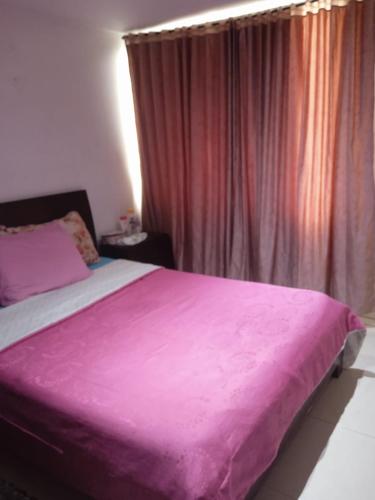 une chambre avec un lit avec une couverture rose dans l'établissement Habitaciones Luna IX, à Chía