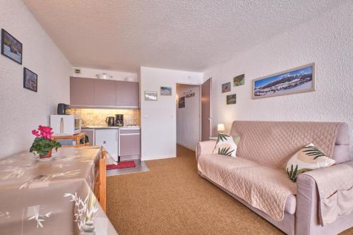 un salon avec un canapé et une cuisine dans l'établissement Studio Herboully, à Corrençon-en-Vercors