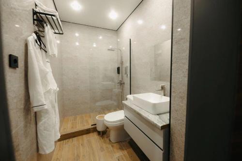 a bathroom with a toilet and a sink and a shower at Irislux in Taraz
