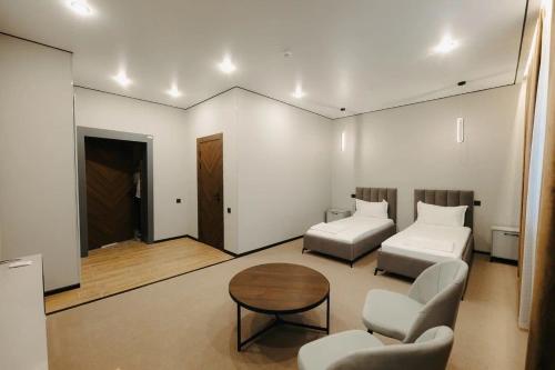 a living room with a bed and a table at Irislux in Taraz