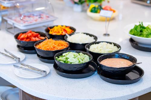 a buffet with bowls of vegetables and dip on a counter at Vientiane Yooeun Hotel in Vientiane