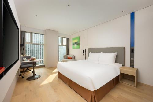 Una habitación de hotel con una cama grande y un televisor. en Holiday Inn Express Hangzhou Huanglong, en Hangzhou