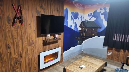 un salon avec une télévision et une cheminée dans l'établissement Le Chalet - Changer d'air en Moselle, à Longeville-lès-Saint-Avold