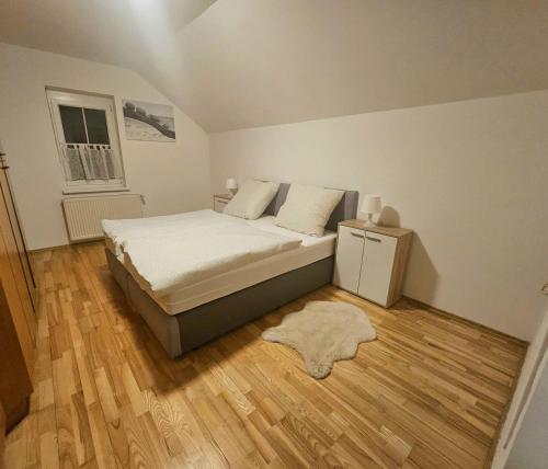 a bedroom with a bed and a wooden floor at Idyllisches Ferienhaus Parndorf in Parndorf