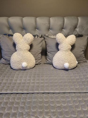 two stuffed rabbits sitting on a bed at Few Steps to the Bay in Jūrmala