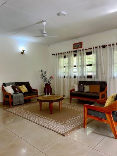 a living room with couches and a coffee table at Kivuli Lodge in Moshi