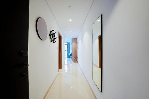 a hallway of a house with white walls and a mirror at Capital Suites Hotel Apartments in Abu Dhabi