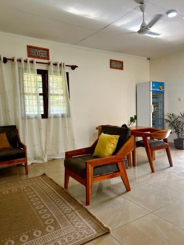 a living room with two chairs and a table at Kivuli Lodge in Moshi