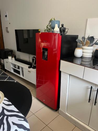 einem roten Kühlschrank in der Mitte einer Küche in der Unterkunft B-Hive at Devland Room 3 in Soweto