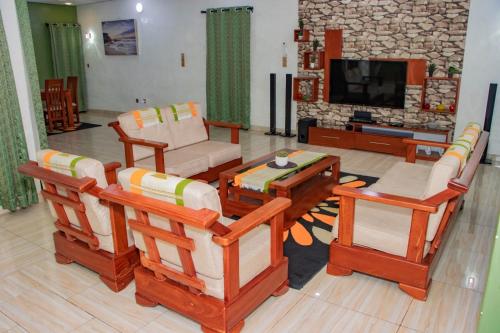 a living room with several chairs and a television at ODG Cotonou - Résidences Océan De Grâce in Cotonou