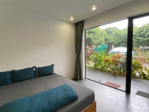 a bedroom with a bed and a large window at Large Mango Villa in Ba Vì