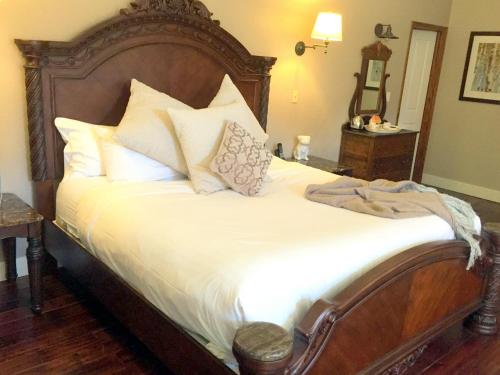 a bedroom with a large bed with white sheets and pillows at The Georgetown Inn in Canmore