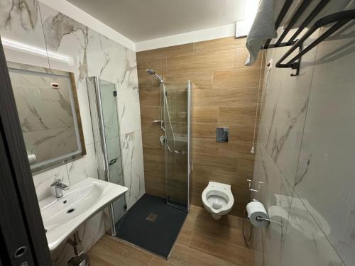 a bathroom with a shower and a sink and a toilet at Hotel Cocceio in Bacoli