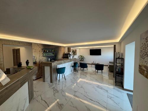 a kitchen and living room with a bar and chairs at Hotel Cocceio in Bacoli