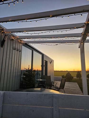 a patio with a table and chairs under a pergola at Cozy Hut with the included Hot Tub-Prime Rentals in Karališkiai