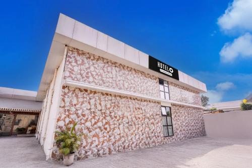 a building with a sign on the side of it at Super Hotel O Palava Dombivali in Mangrul