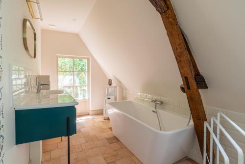 La salle de bains est pourvue d'une grande baignoire et d'un lavabo. dans l'établissement Idéal Groupes 3 Gîtes, 4 Chambres - Bord de Loire, à Gennes