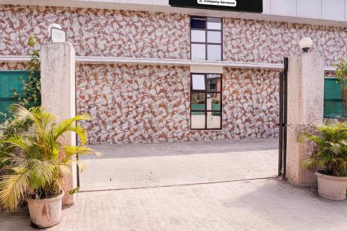 an open door to a building with two plants at Super Hotel O Palava Dombivali in Mangrul