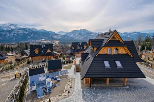 an aerial view of a house with mountains in the background at Odkryj-Zakopane Tatra View Houses & SPA in Kościelisko
