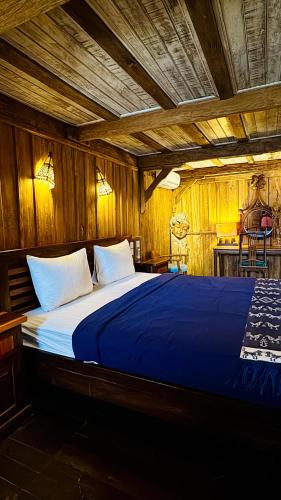 a large bed in a room with wooden walls at Fisherman Shack in Nusa Lembongan