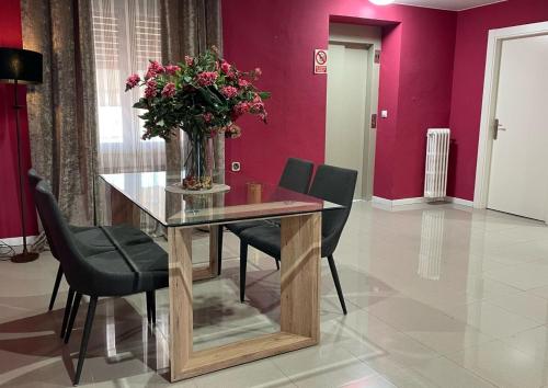 a dining room with a glass table with a vase of flowers at Hotel Fidalgo in Calamocha
