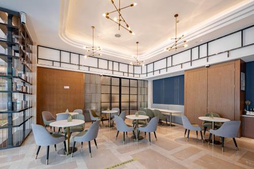 a restaurant with tables and chairs in a building at Yunfei Hotel - Shanghai Hongqiao Wuzhong Road Branch in Shanghai