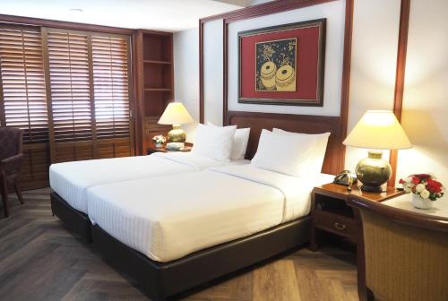 a bedroom with two beds and a desk with two lamps at Centre Point Sukhumvit Thong-Lo in Bangkok