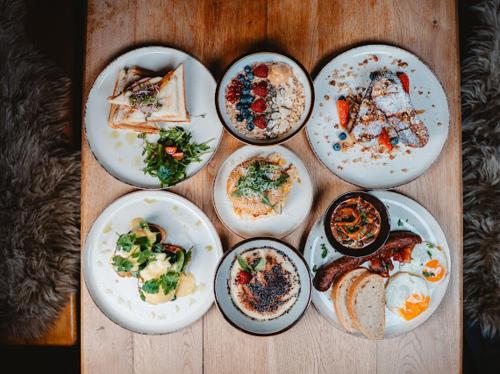 a group of plates of food on a wooden table at Ranč pod Ostrou Skalou in Stratená
