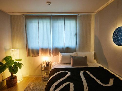 a bedroom with a bed with a large window at Stay Hankan 모던코리아라이프 in Seoul