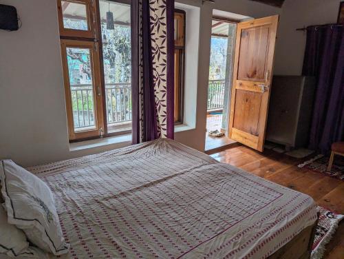 a large bed in a room with windows at Anil farms in Shamshi