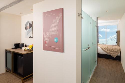 a room with a desk and a door to a bedroom at Voyage Kaohsiung By Cosmos Oasis in Kaohsiung
