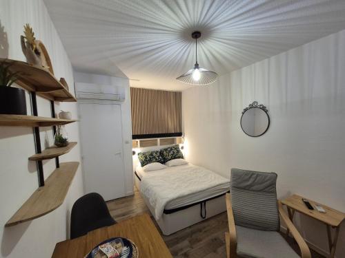 une petite pièce avec un lit et une table dans l'établissement Studio 19m2 classé 1, vue sur étang de Thau, 200m des cures, 2eme Étage sans ascenseur, à Balaruc-les-Bains