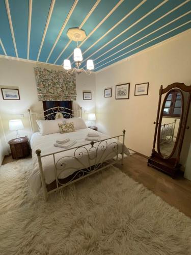 a bedroom with a bed and a blue ceiling at Petrini Armonia, Vitsa Zagori in Vitsa