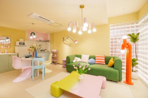 a living room with a green couch and a table at 寅ホテル 御徒町 TORA HOTEL Okachimachi in Tokyo