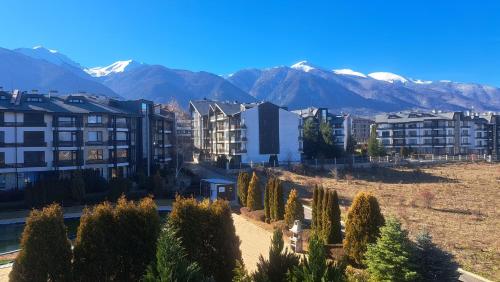a city with buildings and trees and snow capped mountains at Pirin Views Aspen A337 in Razlog