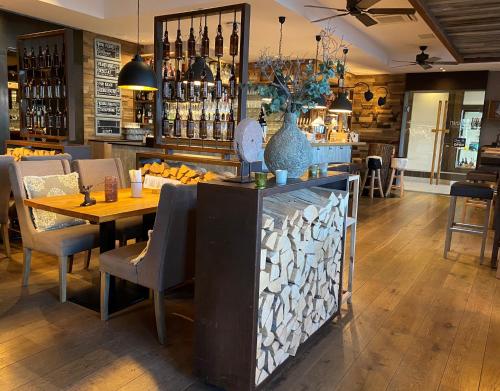 a restaurant with a table and chairs and a bar at Wellings Parkhotel in Kamp-Lintfort