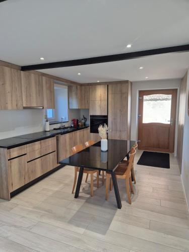 a kitchen with a black table and wooden cabinets at Campagne - appartement rénové avec 2 chambres in Estavayer-le-Lac