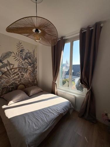 a bedroom with a bed and a large window at Studio 2 Chartres gare et Colisée a 100 m in Chartres