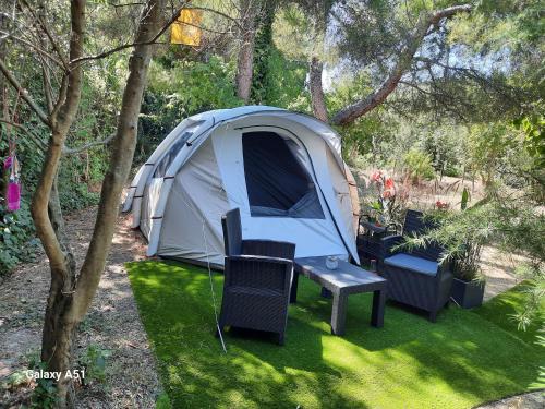 une tente avec une table et des chaises dans une cour dans l'établissement Le Phoenix de la Palmeraie, à Istres