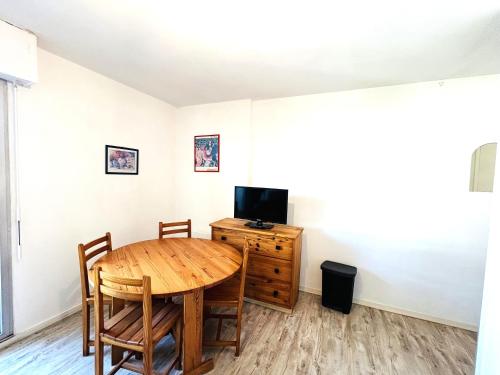 une salle à manger avec une table et une télévision dans l'établissement Appartement 2 pièces 3 personnes - à 200 m de la plage, à Ploemeur