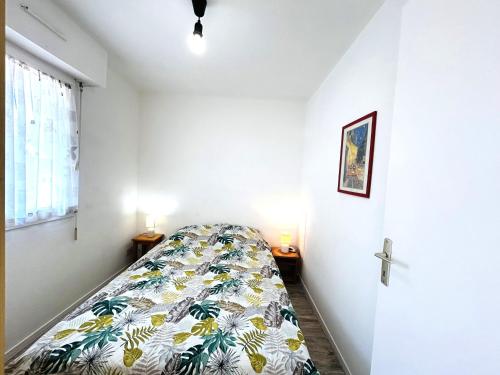 une chambre avec un lit dans une pièce blanche dans l'établissement Appartement 2 pièces 3 personnes - à 200 m de la plage, à Ploemeur