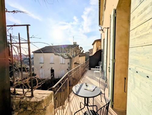 un balcon avec une table et des chaises sur un immeuble dans l'établissement Le Saint Louis - Vue plongeante, à Beaumes-de-Venise
