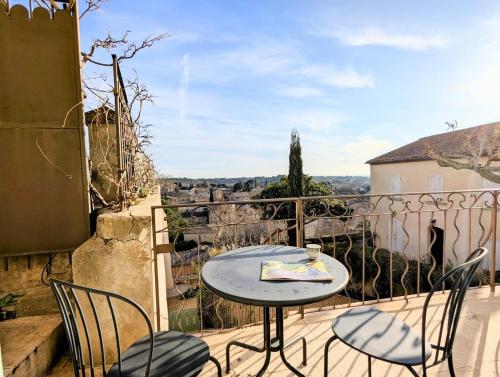 une table et des chaises sur un balcon avec vue dans l'établissement Le Saint Louis - Vue plongeante, à Beaumes-de-Venise