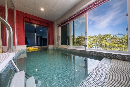 a swimming pool in a house with windows at From H Brown Dot Hotel Gyeongju Yangnam in Gyeongju
