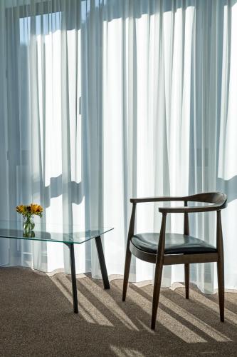 a table and a chair next to a glass table and a window at Ani Forest Hills Hotel and Resort, Dilijan in Dilijan