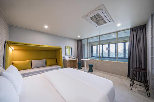 a bedroom with a large bed and a large window at From H Brown Dot Hotel Gyeongju Yangnam in Gyeongju