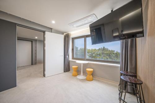 a living room with a large window and a kitchen at From H Brown Dot Hotel Gyeongju Yangnam in Gyeongju
