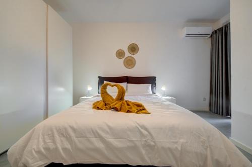 a large white bed with a yellow ribbon on it at Modern Marsaxlokk Apartment in Marsaxlokk