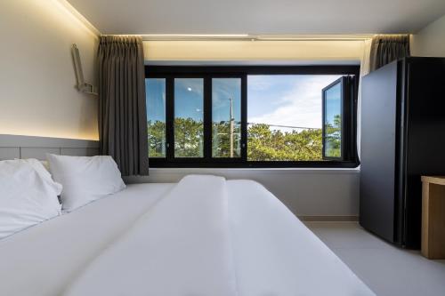 a bedroom with a bed and a large window at From H Brown Dot Hotel Gyeongju Yangnam in Gyeongju