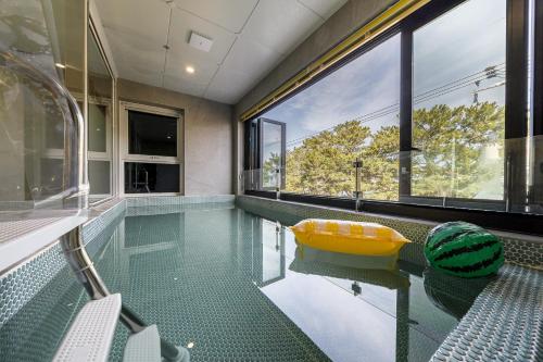 a swimming pool with a yellow tub in a house at From H Brown Dot Hotel Gyeongju Yangnam in Gyeongju